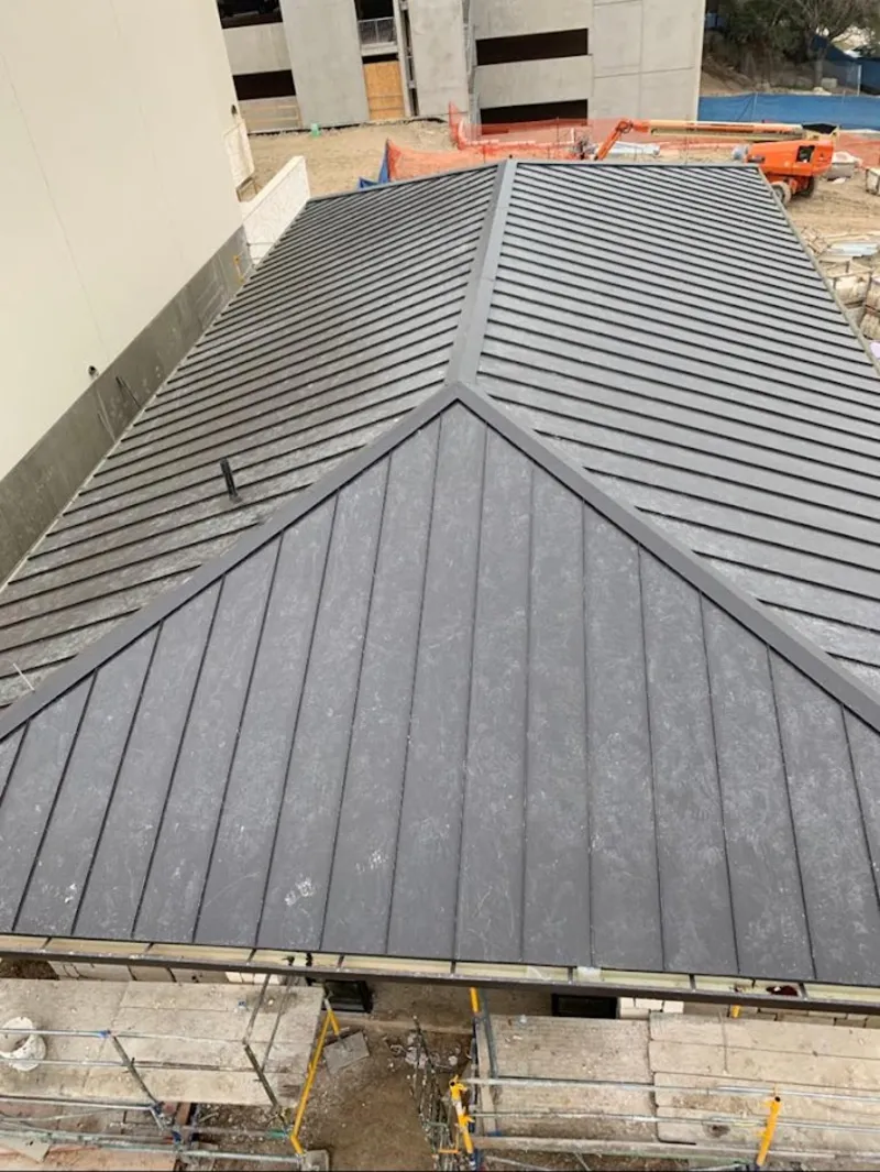 Commercial metal roof construction with crane equipment in East End